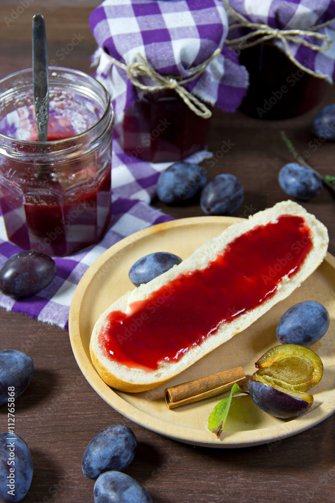 Zwetschgenmarmelade in Gläsern auf Holzbrett und Baguettebrötc Stock ...