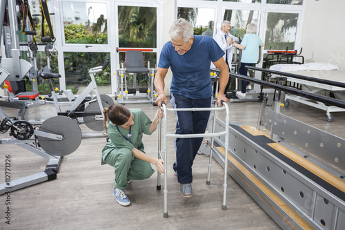 Fotografija Female Nurse Assisting Senior Man With Walker In Fitness Studio
