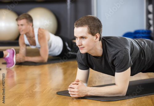 Man Performing Plank Position In Gym