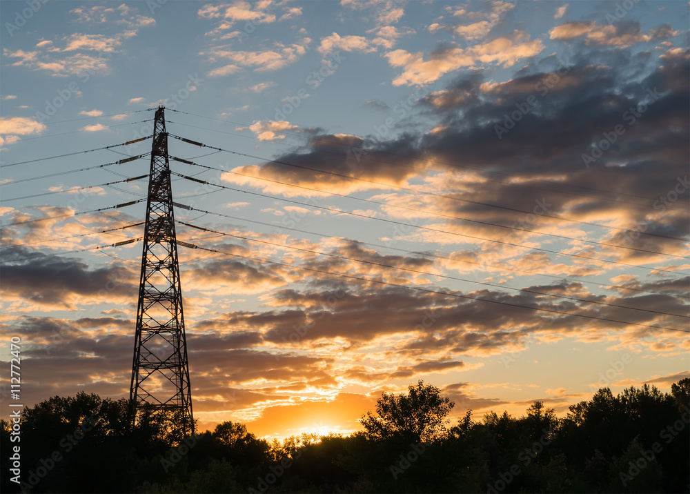 electricity transmission pylon at city suburb against the sunset glow sky. electricity transmission pylon at city suburb against the sunset glow sky.