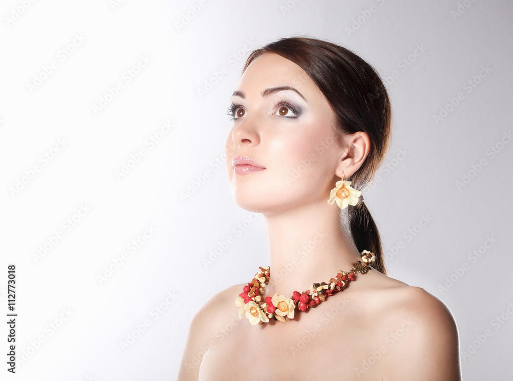 Portrait of young woman with beads, isolated on white background