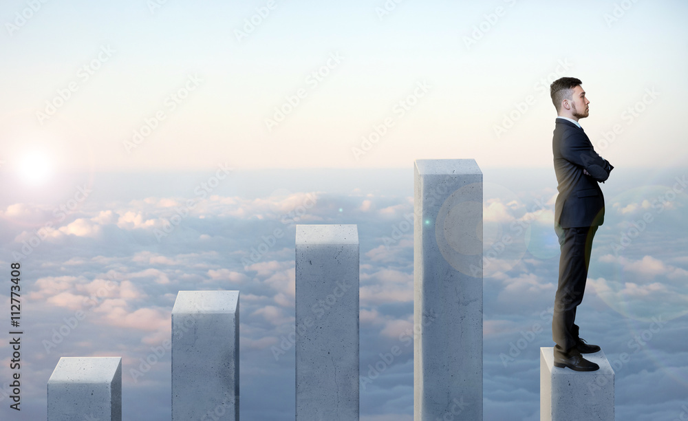 Businessman standing in profile on the latest of five columns with his arms folded Businessman standing in profile on the latest of five columns with his arms folded