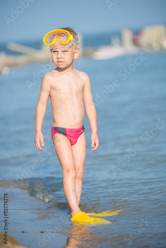 Little boy with snorkel by the sea. Cute little kid wearing mask and flippers for diving at sand tropical beach. Ocean coast.