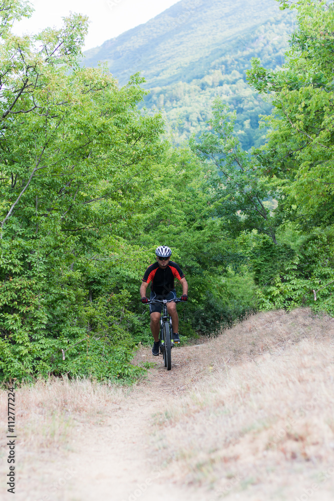 Mountain biker riding cross country Mountain biker riding cross country