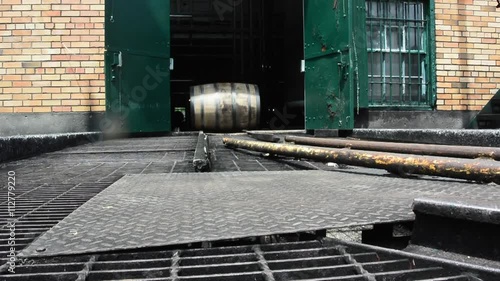 Bourbon Barrel Rolling on Track outside of brick distillery building