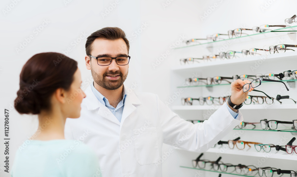 woman and optician showing glasses at optics store woman and optician showing glasses at optics store