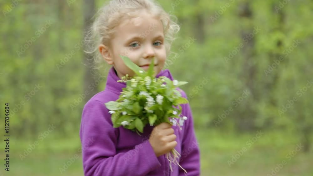 Little girl smelling a daisy flower in the meadow Little girl smelling a daisy flower in the meadow