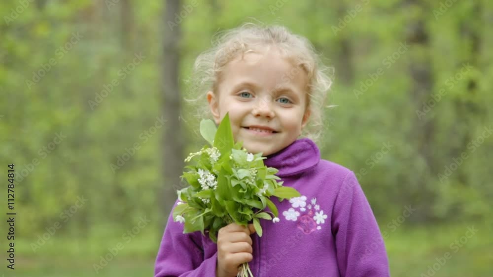 Little girl smelling a daisy flower in the meadow Little girl smelling a daisy flower in the meadow