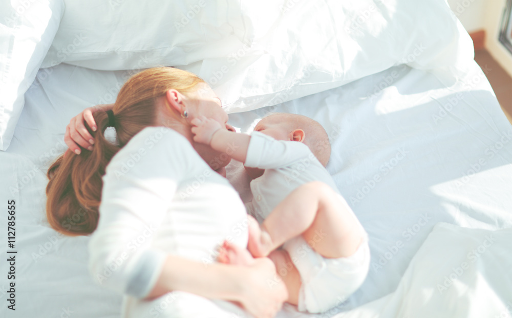 happy family mother with baby playing and hug in bed happy family mother with baby playing and hug in bed