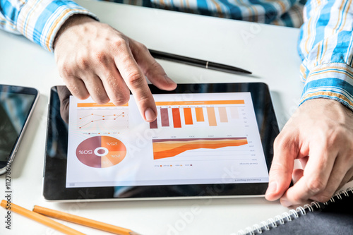 Businessman working with digital Tablet computer with finance report in Office. Business market Research, Economic statistics concept