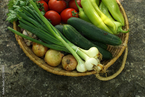 Vegetables in a basket on a stone base