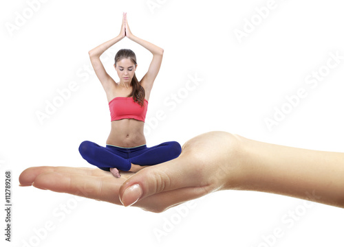 Young beautiful woman doing yoga sitting on hand isolated on white