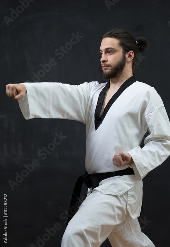 Karate Fighter in white Kimono Isolated on Black with Copy space