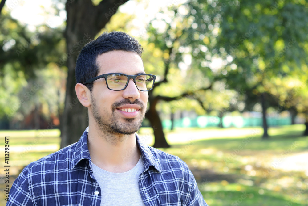 Close up of young man in a park. Close up of young man in a park.