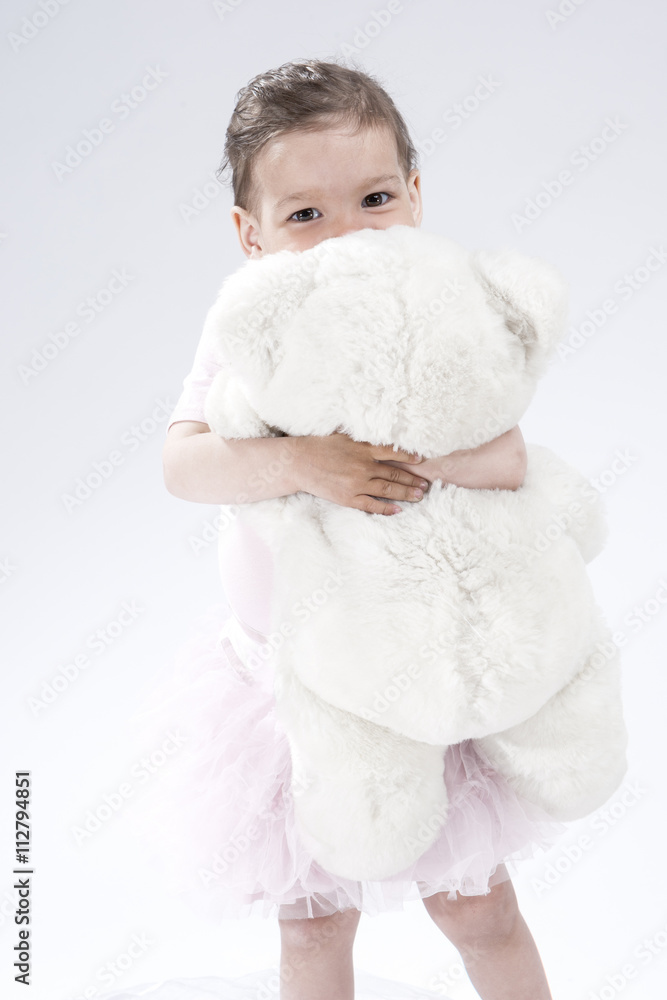 Little Caucasian Cute Female Child. Posing with Toy Against White Background Little Caucasian Cute Female Child. Posing with Toy Against White Background