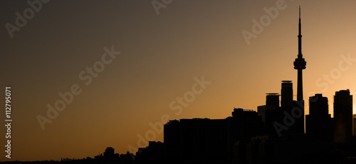 SILHOUETTE OF TORONTO SKYLINE AGAINST AN ORANGE SKY AT SUNSET