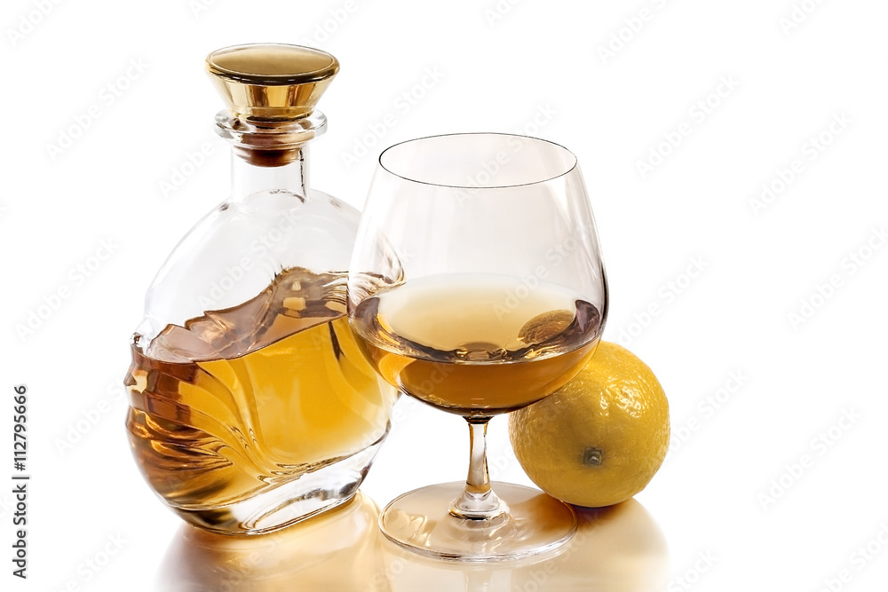 Bottle and snifter brandy with lemon on white background Bottle and snifter brandy with lemon on white background