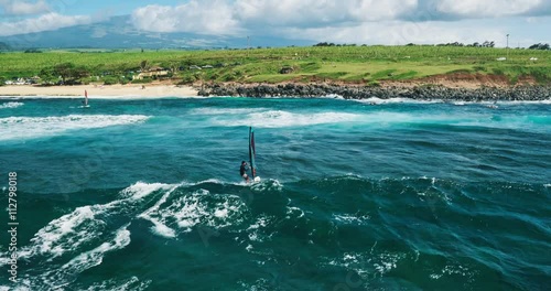 Aerial view of windsurfer gliding across blue ocean, extreme sport