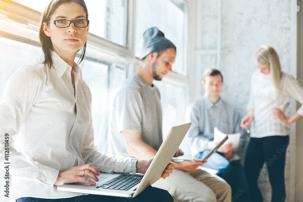 Office process. Project team working in big loft office. Laptop and paperwork Office process. Project team working in big loft office. Laptop and paperwork