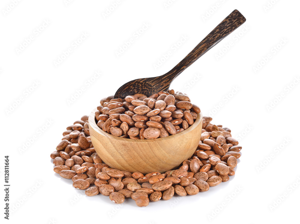 uncooked pinto beans in wooden bowl on white background uncooked pinto beans in wooden bowl on white background