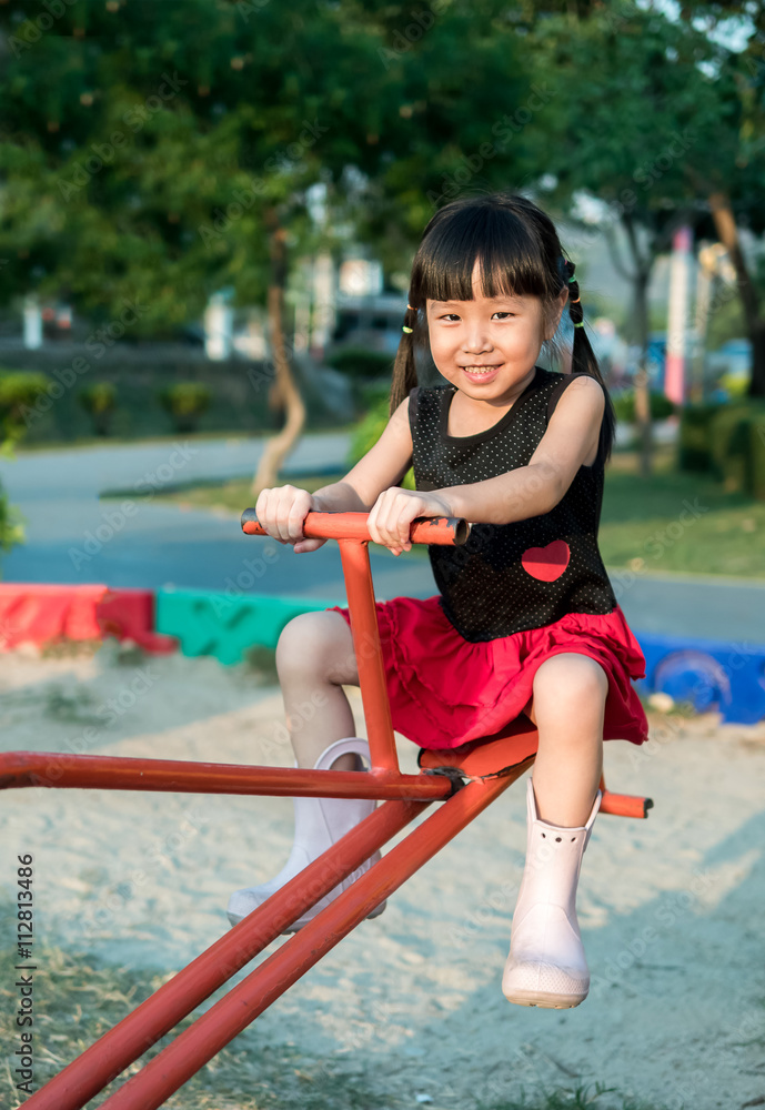Happy kid, asian baby child playing on a seesaw Happy kid, asian baby child playing on a seesaw