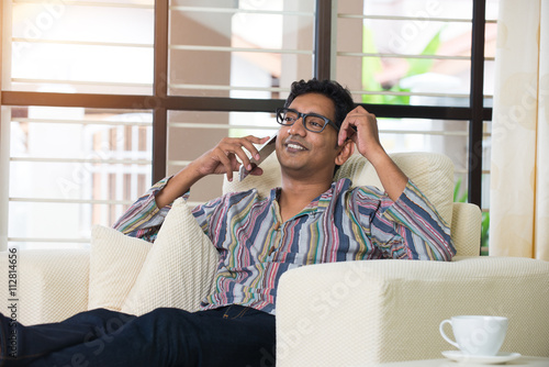 casual indian with smartphone male on sofa