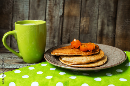 Hot drinks with puncakes on a wooden table photo