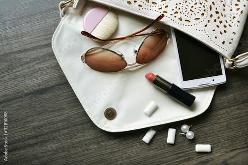 trendy handbag with woman´s treasures and secrecy