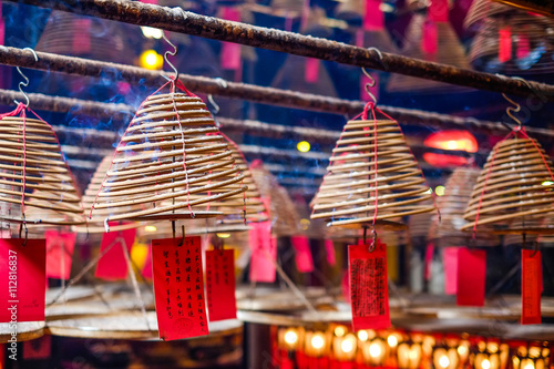 Circular incenses, people pray to god for blessing in traditional old oriental chinese temple in Hong Kong(HK) (Chinese Translation on paper : wish all the best for life)