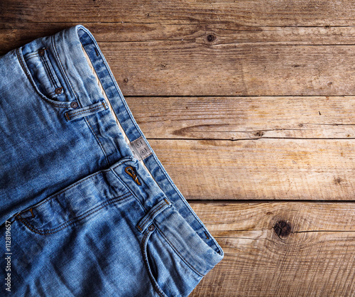 Jeans on a wooden background. The upper part. Clothing, fashion, style, lifestyle