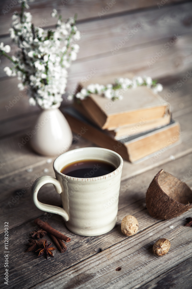 Fototapeta premium Large Cup of coffee on vintage wooden background. Spring flowers and books.