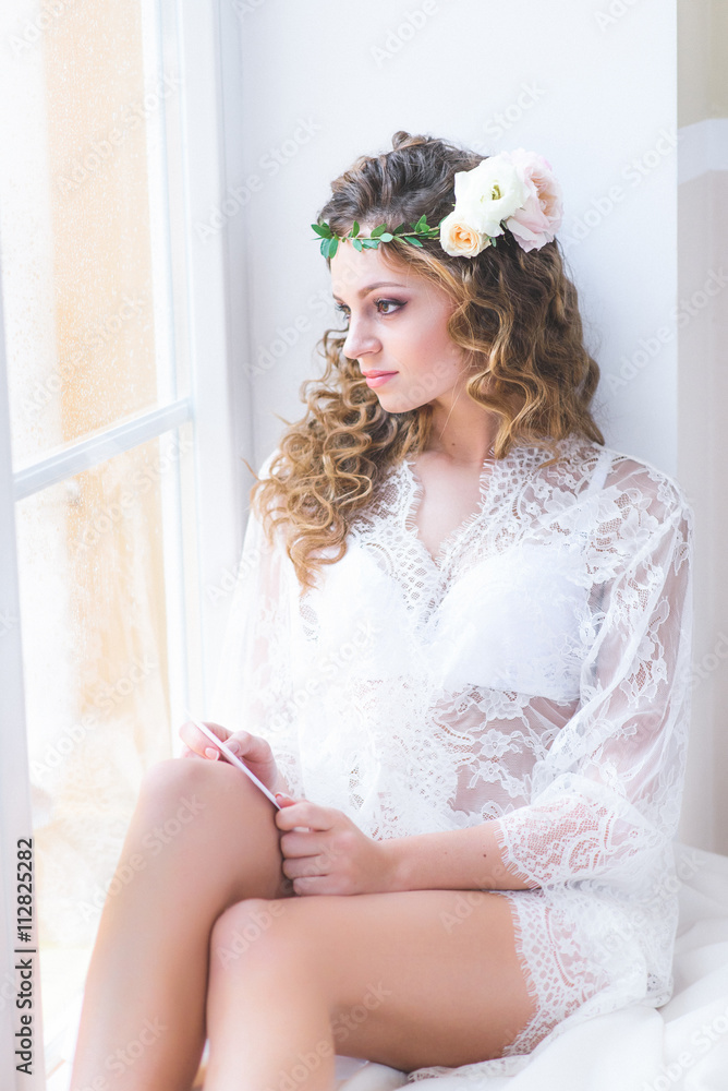 beautiful girl in a white bridal negligee sitting beautiful girl in a white bridal negligee sitting