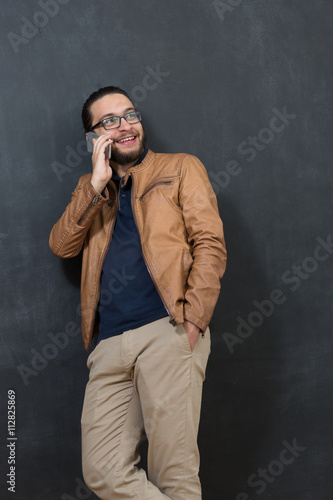 Casually handsome. Handsome young arabic man holding cell phone