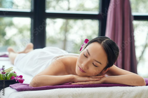 Beautiful Asian woman sleeping after relaxing spa procedure