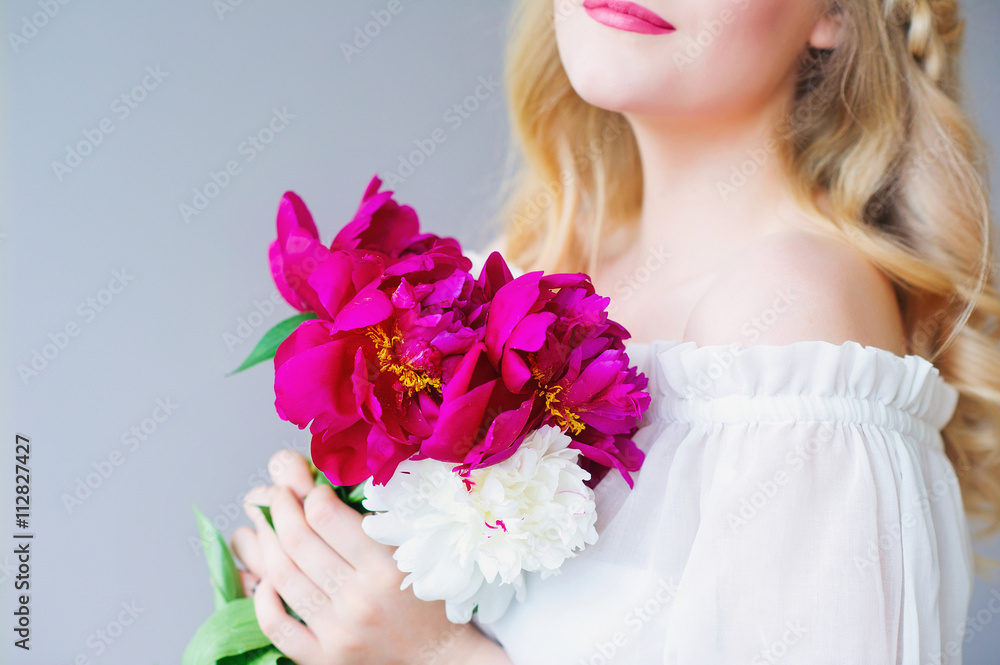 Closeup woman hands holding pink and white peonies