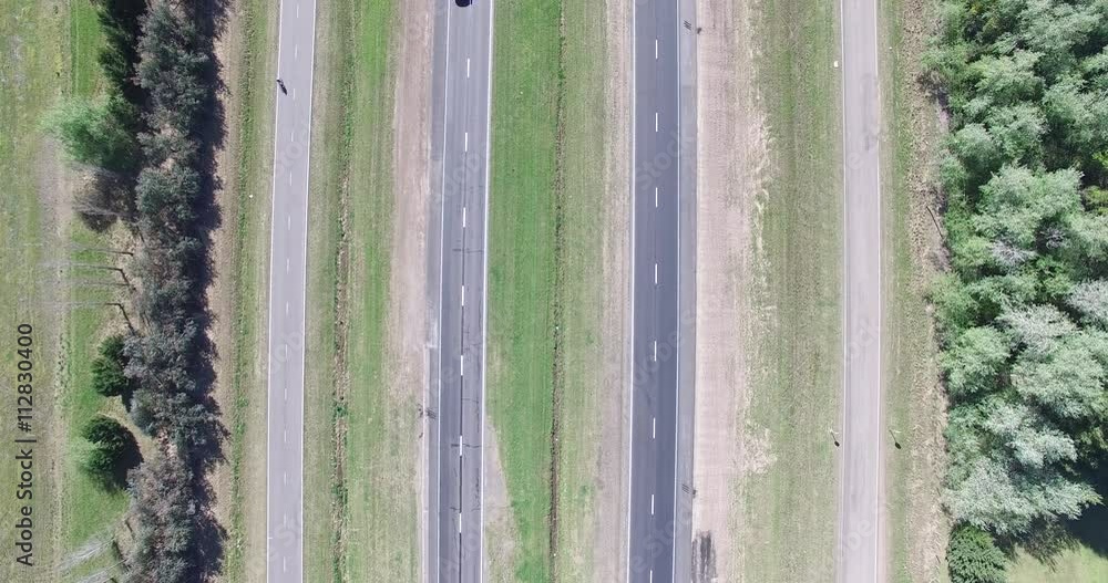 Top aerial scene of highway on the field. Trucks, motorcycle and cars movement is registered on the road. Comera stays still. Top aerial scene of highway on the field. Trucks, motorcycle and cars movement is registered on the road. Comera stays still.