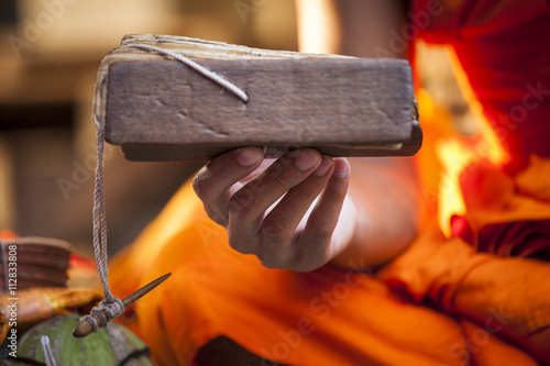 Asian monk with orange tunic read the future in Angkor Wat temple, Cambodia.  photo