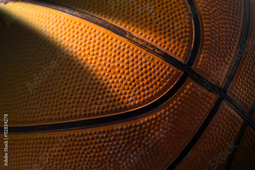 Macro photo of an old black and orange basketball with dark shadow