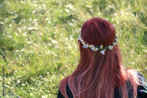 Unrecognizable girl wearing daisy flower crown in her hair. Selective focus. 