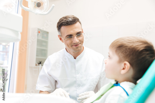 Dentist examining teeth of little boy
