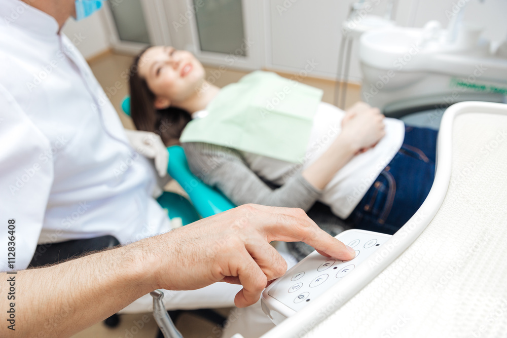 Male dentist using computer in his work with female patient Male dentist using computer in his work with female patient