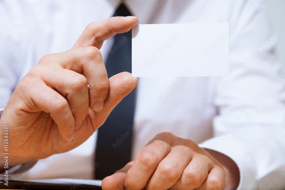 Businessman holding a business card Businessman holding a business card