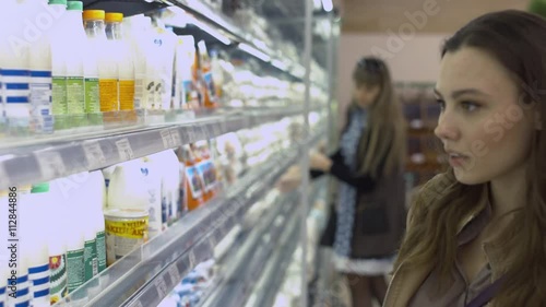 Beautiful shopper chooses dairy products in the store