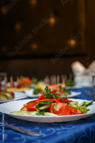 Variety of delicious dishes on plates on blue tablecloth at restaurant