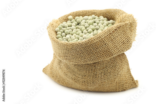 green peas in a burlap bag on a white background