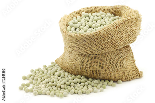 green peas in a burlap bag on a white background