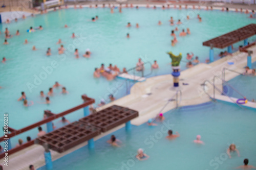 Blurred image of outdoor pool with people bathing
