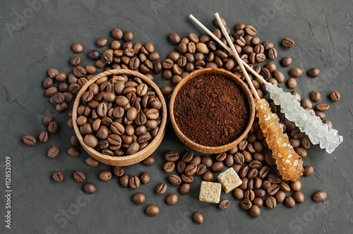 Coffee beans and ground coffee in a wooden bowl and cane sugar