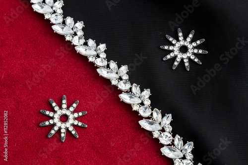 Fototapeta Naklejka Na Ścianę i Meble -  Necklace and earring on a red and black fabric