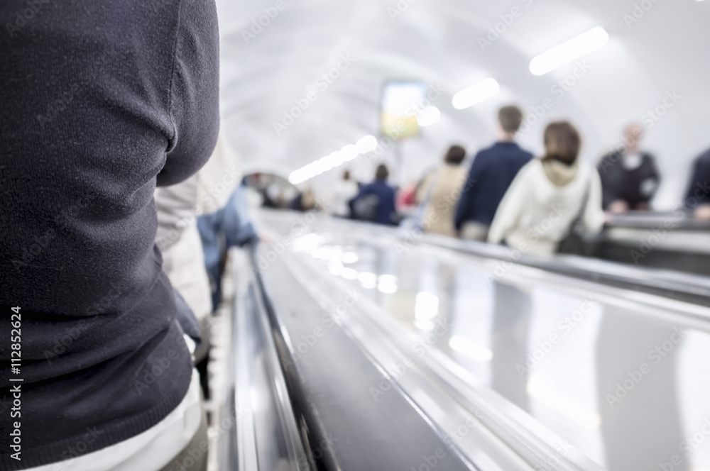 people go on the escalator on a long circular tunnel people go on the escalator on a long circular tunnel